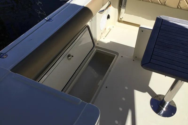 Slide: The Image of 2016 Chris-Craft Calypso 26 boat interior with storage compartment and seating. - 17