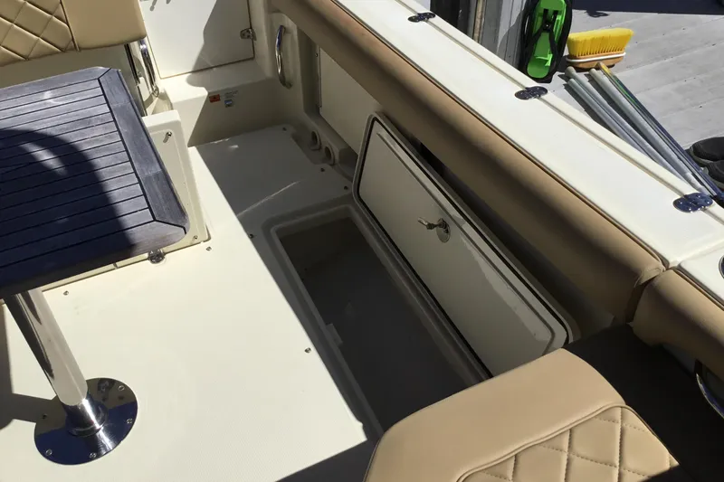 Slide: The Image of 2016 Chris-Craft Calypso 26 boat interior with seating and storage compartment. - 18