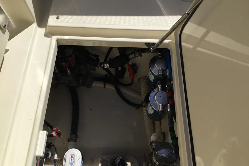 Slide: The Image of 2016 Chris-Craft Calypso 26 engine compartment with visible hoses and components. - 23