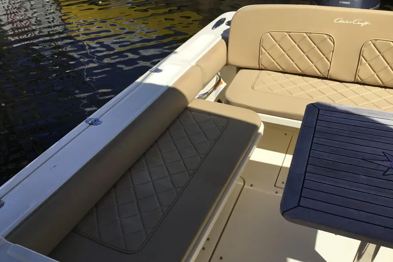 Slide: The Image of 2016 Chris-Craft Calypso 26 boat interior with tan seating and wooden table. - 27