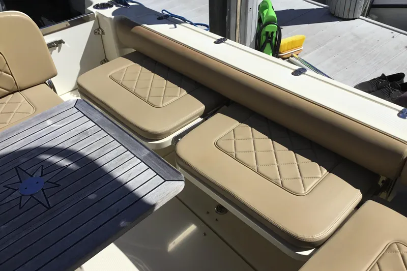 Slide: The Image of 2016 Chris-Craft Calypso 26 interior with beige seating and wooden table. - 28