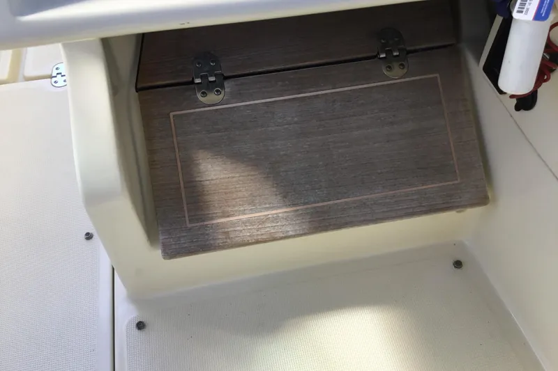 Slide: The Image of 2016 Chris-Craft Calypso 26 boat interior with wooden storage compartment. - 34