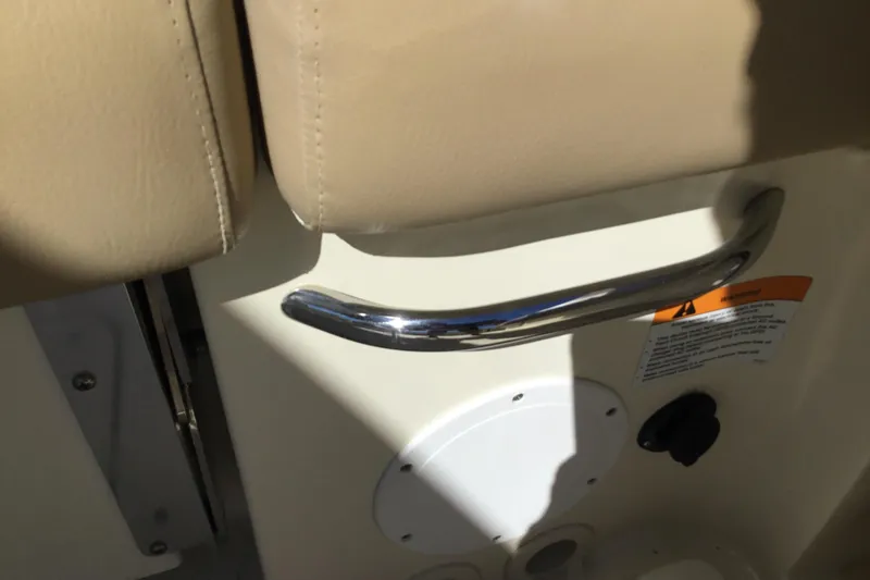 Slide: The Image of 2016 Chris-Craft Calypso 26 interior detail with beige upholstery and chrome handle. - 47