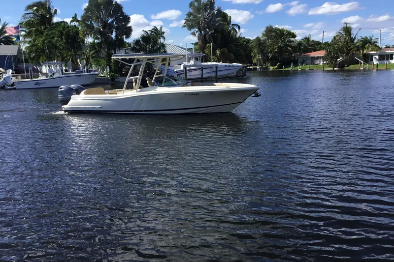 Slide: The Image of 2016 Chris-Craft Calypso 26 boat cruising on a sunny, tropical waterway. - 50