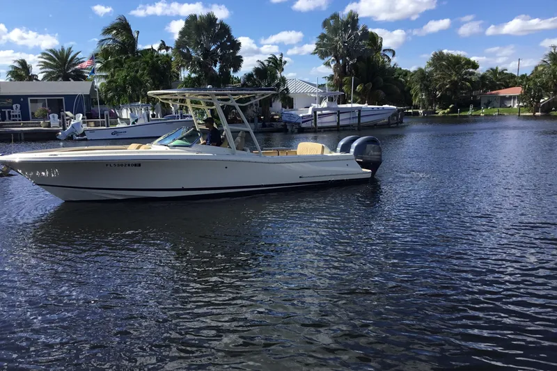 Slide: The Image of 2016 Chris-Craft Calypso 26 boat cruising on a sunny day in a scenic waterway. - 55