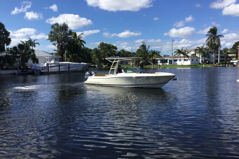 Slide: The Image of 2016 Chris-Craft Calypso 26 boat cruising on a sunny, tropical waterway. - 59