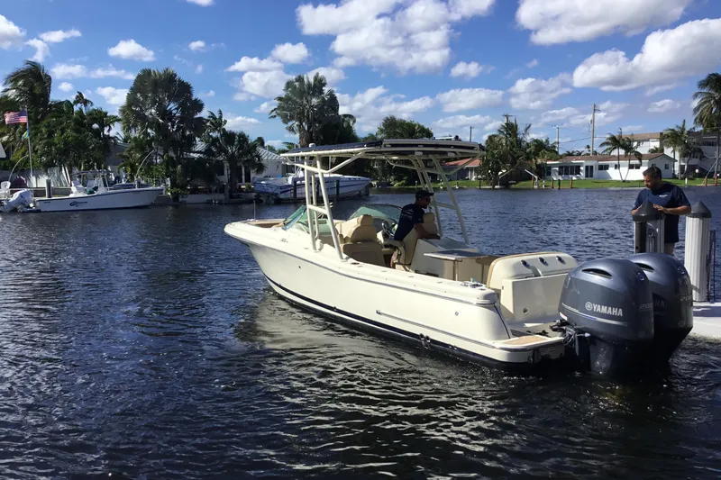 Slide: The Image of 2016 Chris-Craft Calypso 26 boat on a sunny day, docked by a waterfront. - 61