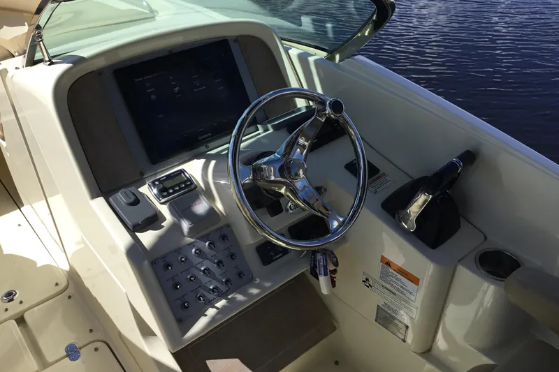 Slide: The Image of 2016 Chris-Craft Calypso 26 boat dashboard with steering wheel and control panel. - 7