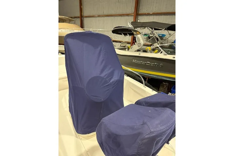 Slide: The Image of 2008 Boston Whaler 190 Outrage boat with blue protective covers in storage. - 2