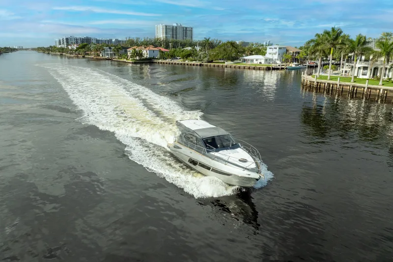 Slide: The Image of Valiatt 410HT 2025 cruising on a scenic waterway with waterfront homes. - 10