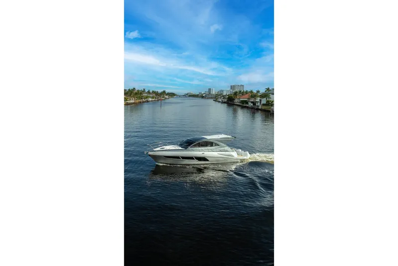 Slide: The Image of Valiatt 410HT 2025 yacht cruising on a scenic waterway under a clear blue sky. - 12