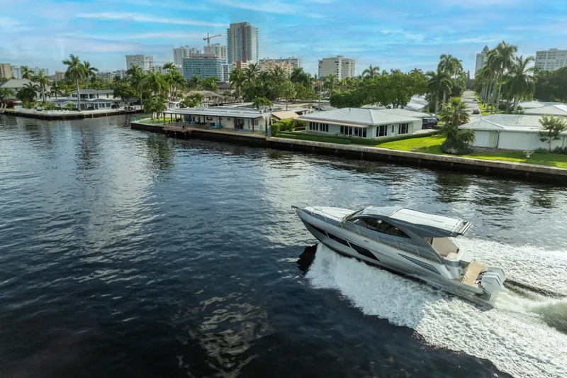 Slide: The Image of Valiatt 410HT 2025 yacht cruising on a scenic urban waterway. - 18