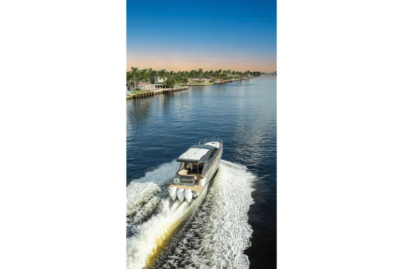 Slide: The Image of Valiatt 410HT 2025 boat cruising on a scenic waterway at sunset. - 20