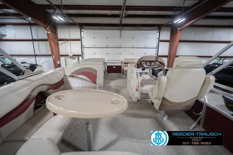 Slide: The Image of 2010 Sylvan 8522 Mirage Cruise interior with seating and steering console in a showroom. - 19