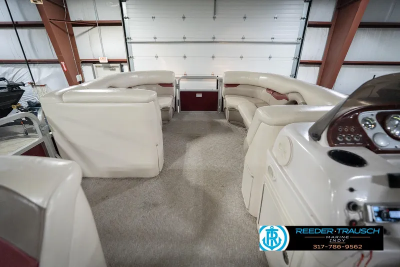 Slide: The Image of 2010 Sylvan 8522 Mirage Cruise interior with beige seating in a garage setting. - 20