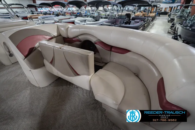 Slide: The Image of 2010 Sylvan 8522 Mirage Cruise boat interior with beige and maroon seating in showroom. - 23