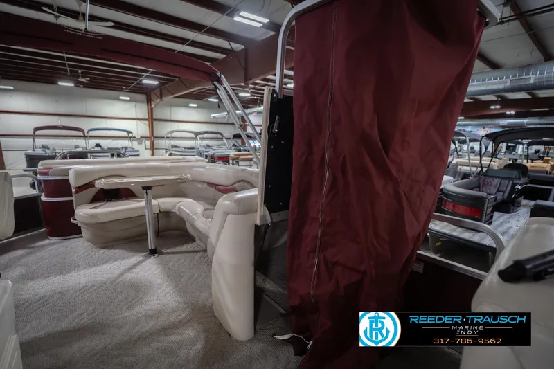 Slide: The Image of 2010 Sylvan 8522 Mirage Cruise pontoon boat interior in showroom with maroon accents. - 26