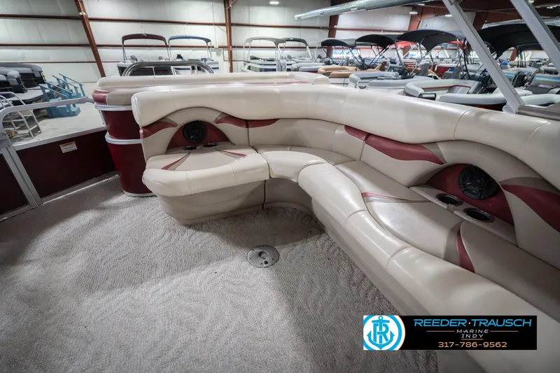 Slide: The Image of 2010 Sylvan 8522 Mirage Cruise pontoon interior with beige and red seating in showroom. - 28