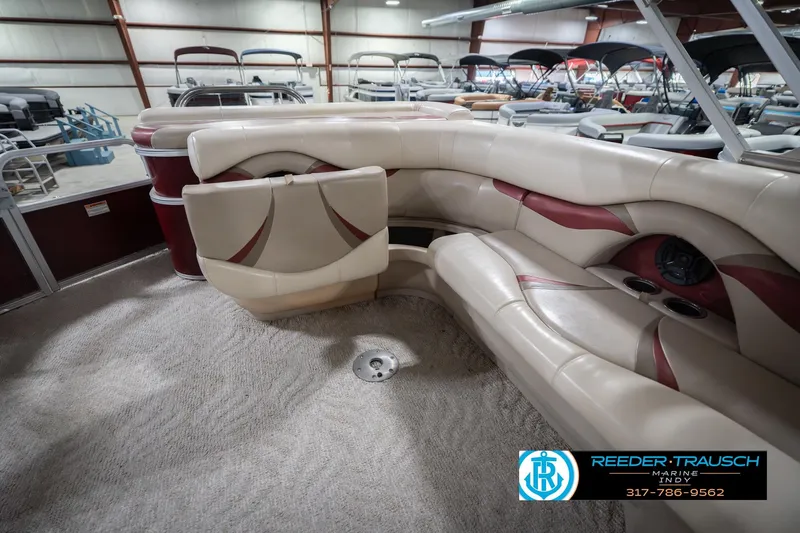 Slide: The Image of 2010 Sylvan 8522 Mirage Cruise boat interior with beige and red seating in showroom. - 29