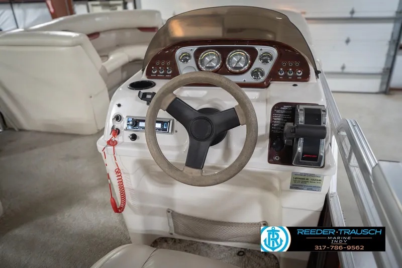 Slide: The Image of 2010 Sylvan 8522 Mirage Cruise boat dashboard with steering wheel and controls. - 31