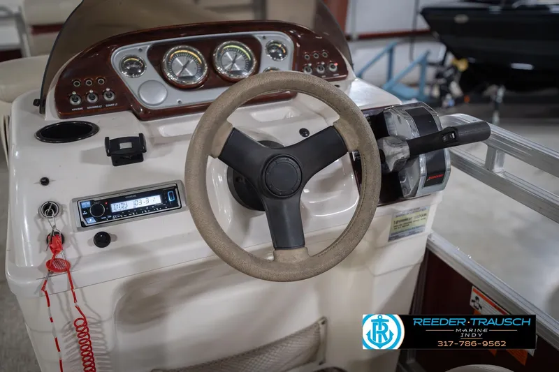 Slide: The Image of 2010 Sylvan 8522 Mirage Cruise boat dashboard with steering wheel and control panel. - 32