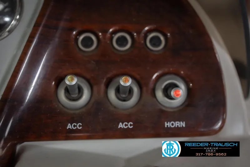 Slide: The Image of Dashboard switches of a 2010 Sylvan 8522 Mirage Cruise boat, featuring accessory and horn controls. - 37