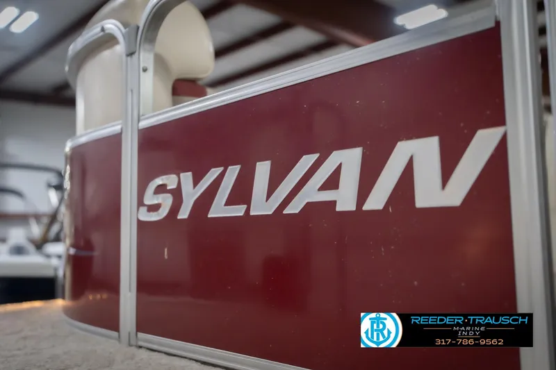 Slide: The Image of 2010 Sylvan 8522 Mirage Cruise boat with red paneling in indoor showroom. - 52