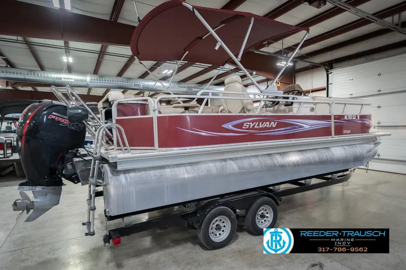 Slide: The Image of 2010 Sylvan 8522 Mirage Cruise pontoon boat in indoor showroom with Mercury Pro XS engine. - 8