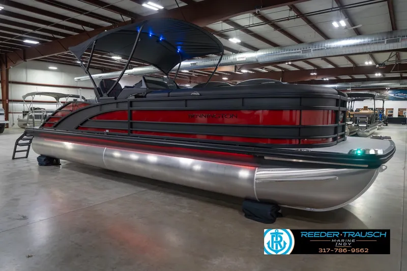 Slide: The Image of 2026 Bennington 25 RSB pontoon boat in showroom with canopy and sleek design. - 6