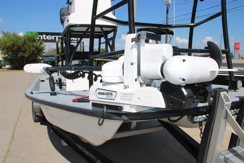 Slide: The Image of 2024 Shoalwater 23 Catamaran boat with seating and outboard motor in a marina setting. - 16