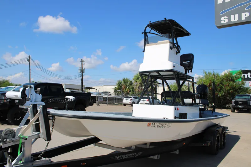 Slide: The Image of 2024 Shoalwater 23 Catamaran boat with seating and storage, parked on a trailer. - 20