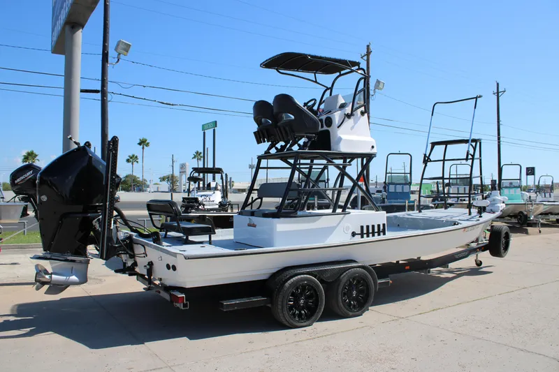 Slide: The Image of 2024 Shoalwater 23 Catamaran with outboard motor at dealership. - 7