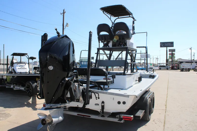 Slide: The Image of 2024 Shoalwater 23 Catamaran with elevated seating, displayed outdoors near a dealership. - 8