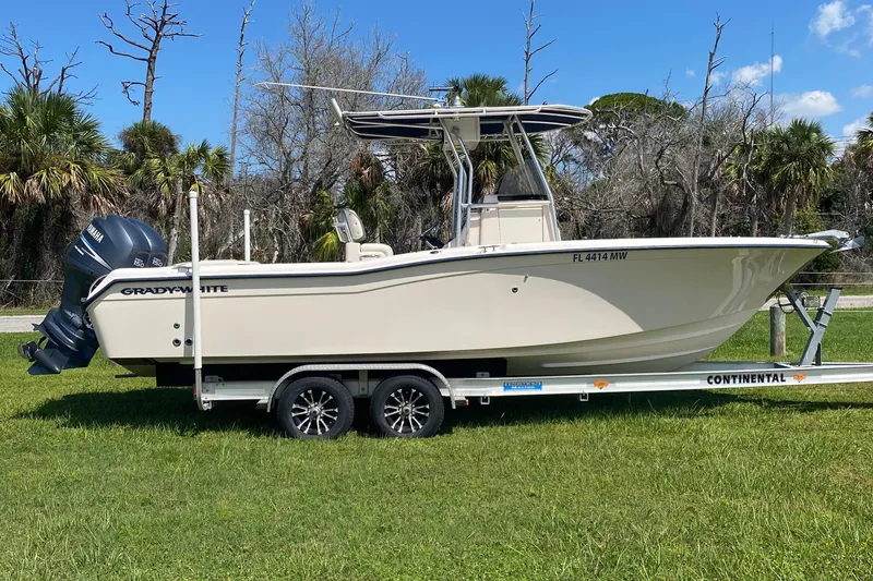 Slide: The Image of 2005 Grady-White Advance 257 boat on trailer, parked on grass, with Yamaha outboard motor. - 0