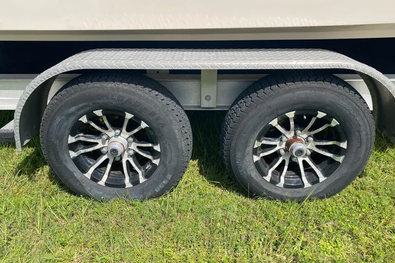 Slide: The Image of Trailer wheels of a 2005 Grady-White Advance 257 boat on grass. - 11