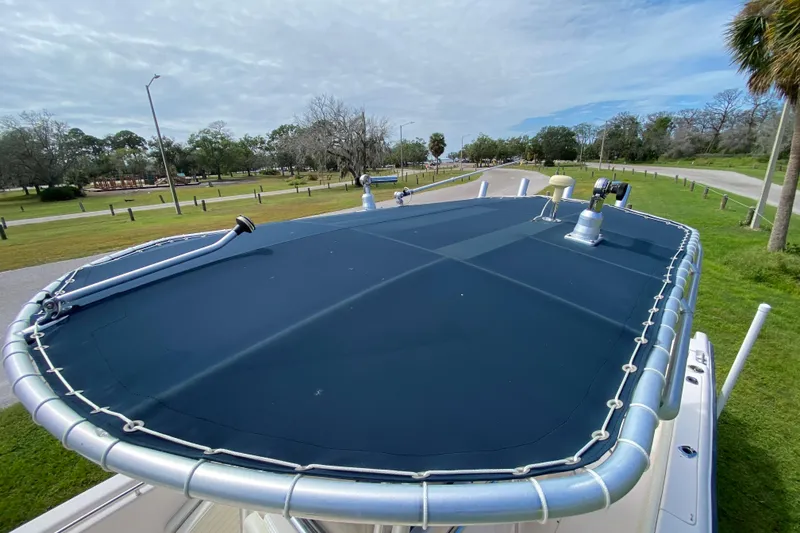 Slide: The Image of 2005 Grady-White Advance 257 boat with blue canvas top, parked in a scenic area. - 110