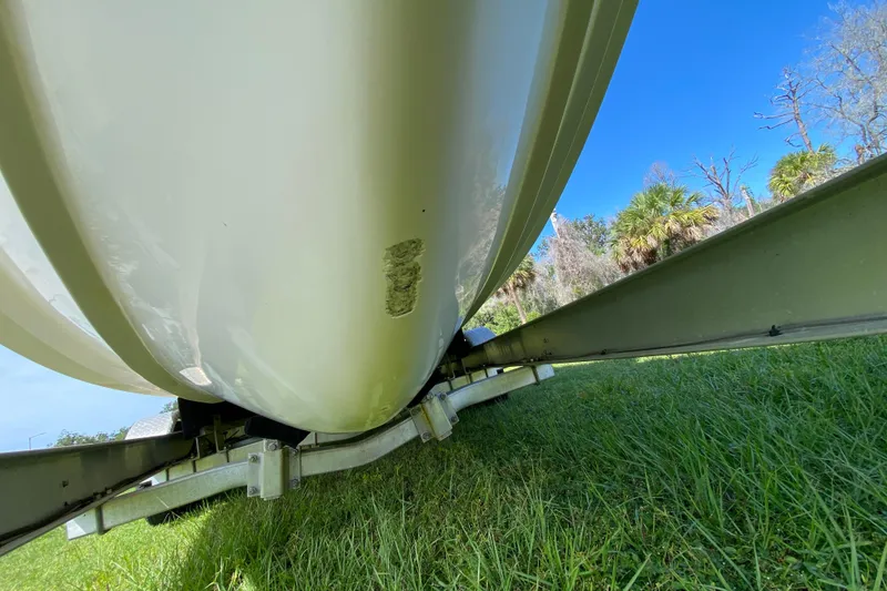 Slide: The Image of 2005 Grady-White Advance 257 boat hull on trailer, grassy area, clear blue sky. - 15