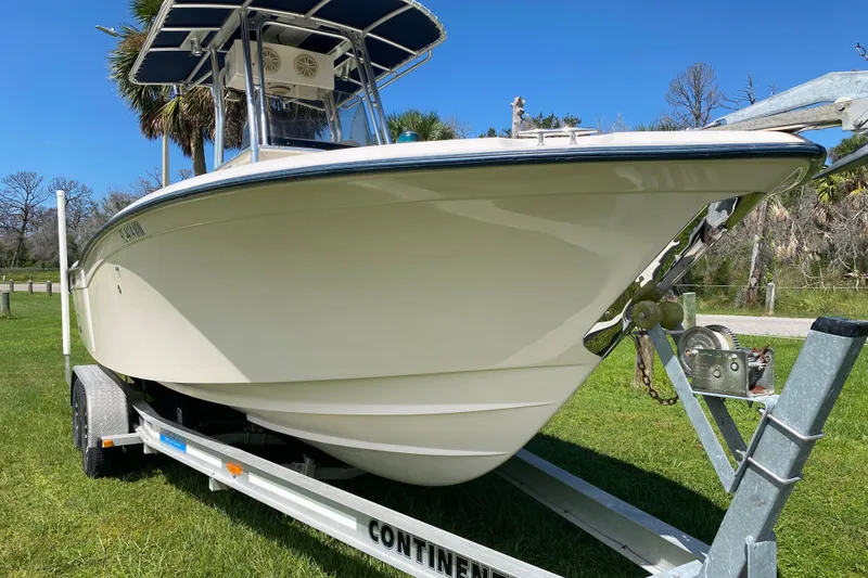 Slide: The Image of 2005 Grady-White Advance 257 boat on trailer, parked on grass under clear blue sky. - 2