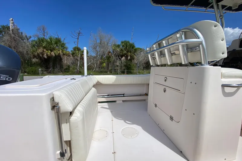 Slide: The Image of 2005 Grady-White Advance 257 boat interior with seating and storage, under clear blue sky. - 29