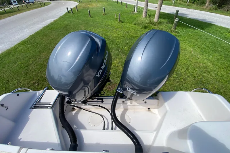 Slide: The Image of 2005 Grady-White Advance 257 boat with dual Yamaha outboard motors, parked on grass. - 32