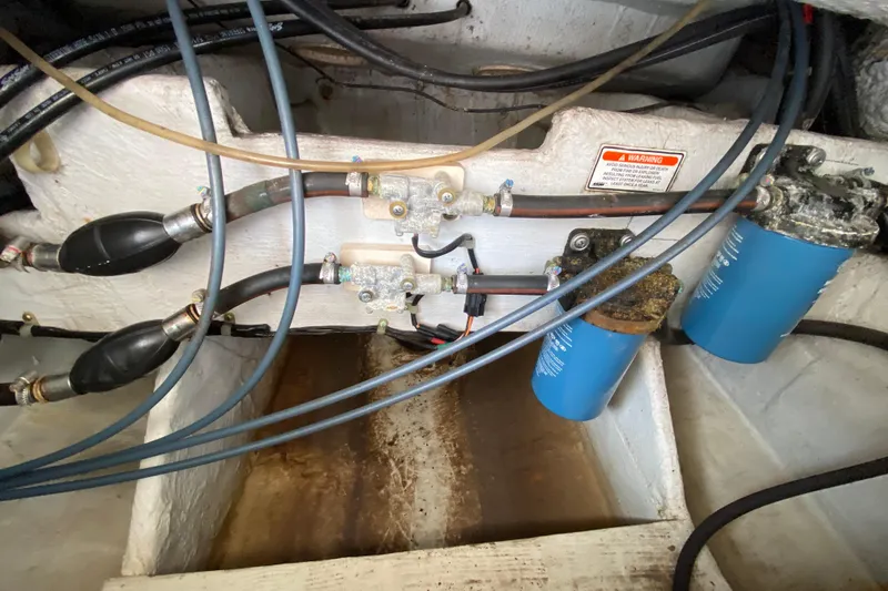 Slide: The Image of 2005 Grady-White Advance 257 boat engine compartment with fuel filters and hoses. - 46