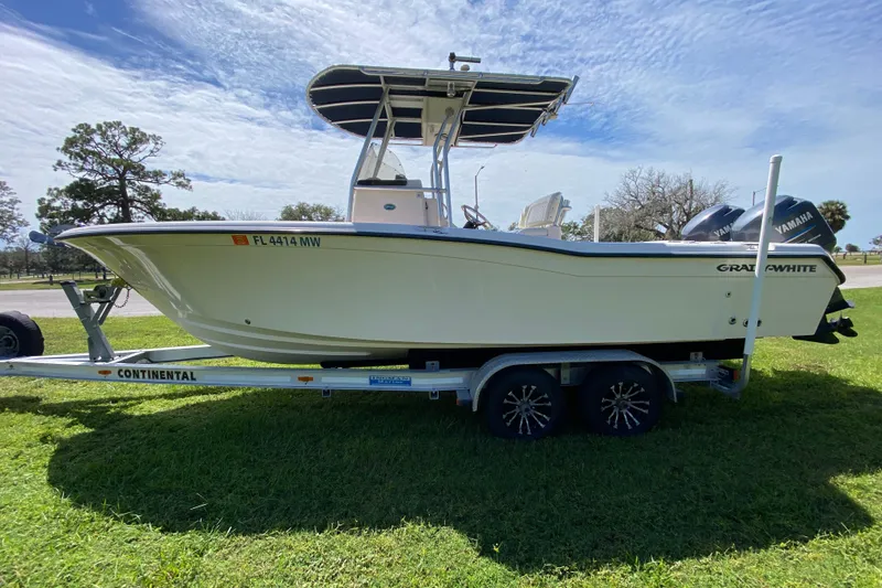 Slide: The Image of 2005 Grady-White Advance 257 boat on trailer, parked on grass under a blue sky. - 5
