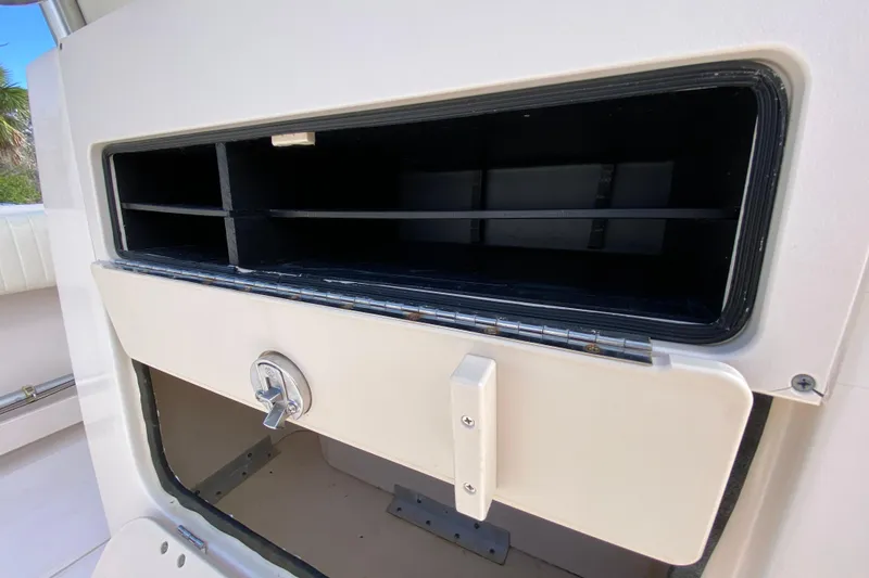 Slide: The Image of 2005 Grady-White Advance 257 boat storage compartment with open hatch and lock. - 53