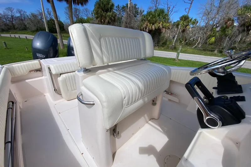 Slide: The Image of 2005 Grady-White Advance 257 boat interior with white seating and steering wheel. - 56