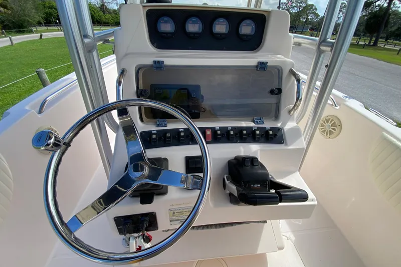 Slide: The Image of 2005 Grady-White Advance 257 boat console with steering wheel and control panel. - 61