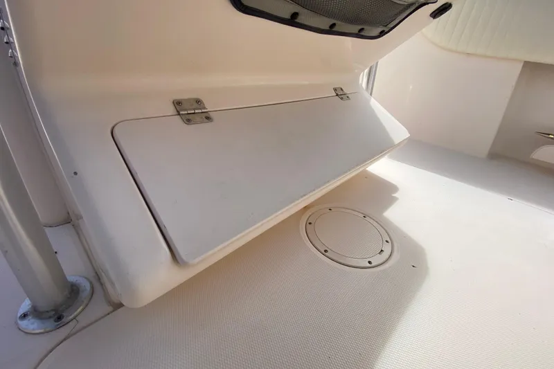Slide: The Image of 2005 Grady-White Advance 257 boat interior, featuring storage compartment and deck details. - 69
