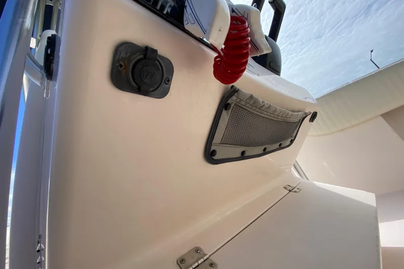 Slide: The Image of 2005 Grady-White Advance 257 boat interior with 12V outlet and storage pocket. - 71