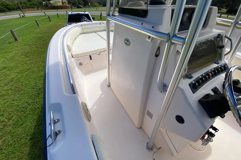 Slide: The Image of 2005 Grady-White Advance 257 boat interior with console and seating, parked on grass. - 76