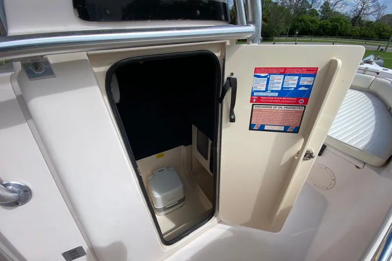 Slide: The Image of 2005 Grady-White Advance 257 boat with open cabin door revealing interior storage space. - 78