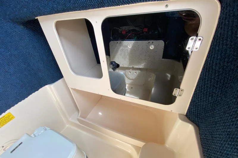 Slide: The Image of 2005 Grady-White Advance 257 boat interior with storage compartment and toilet. - 80